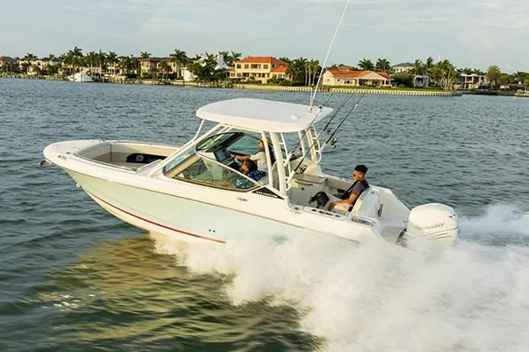 Blue Horizons II Yacht Photos Pics Manufacturer Provided Image: 2023 Boston Whaler 240 Vantage cruising on water near coastal homes.