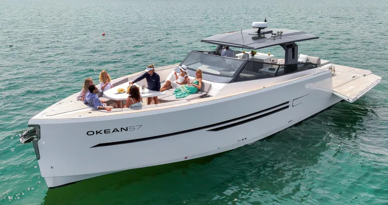  Yacht Photos Pics 2023 OKEAN 57 yacht with people relaxing on deck in open water.