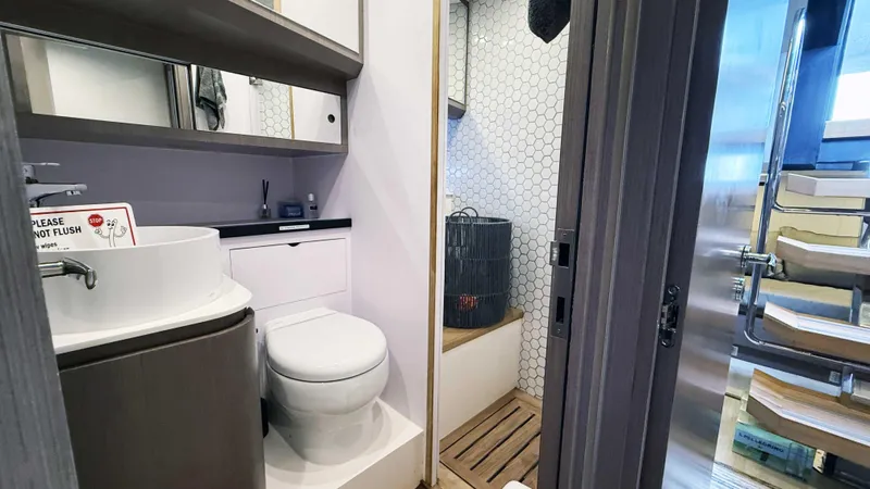  Yacht Photos Pics Modern bathroom on 2023 OKEAN 57 yacht with sleek fixtures and hexagonal tile design.