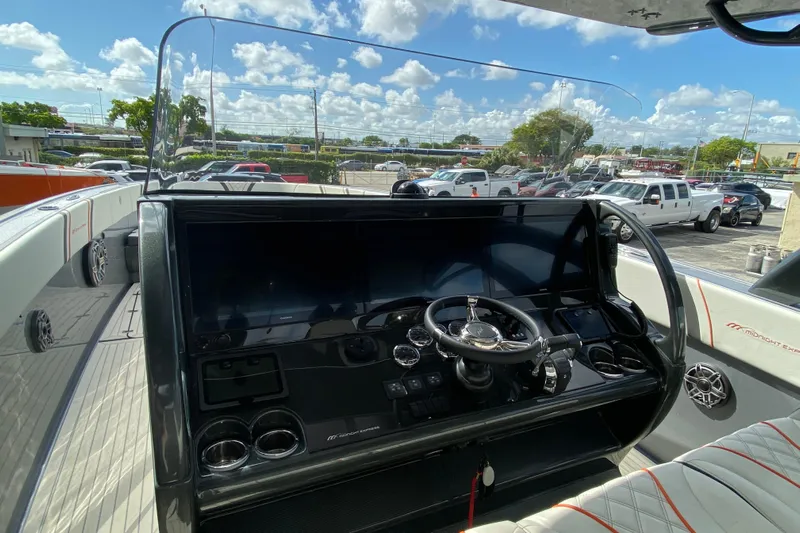  Yacht Photos Pics Midnight Express 43 Open boat dashboard with steering wheel and controls, parked outdoors.