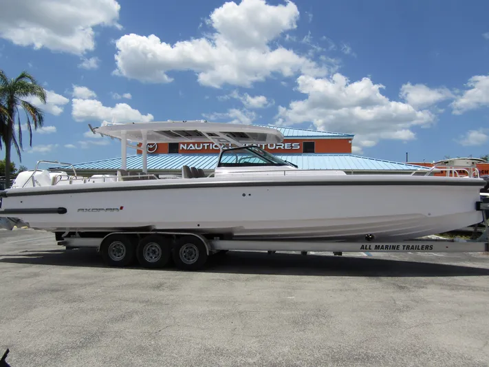  Yacht Photos Pics 2024 Axopar 37 Sun Top boat on trailer under blue sky.
