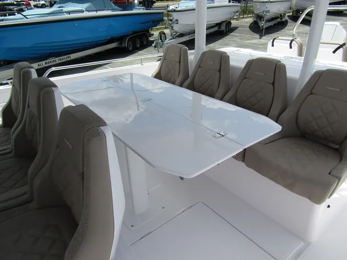  Yacht Photos Pics 2024 Axopar 37 Sun Top boat interior with beige cushioned seating and white table.