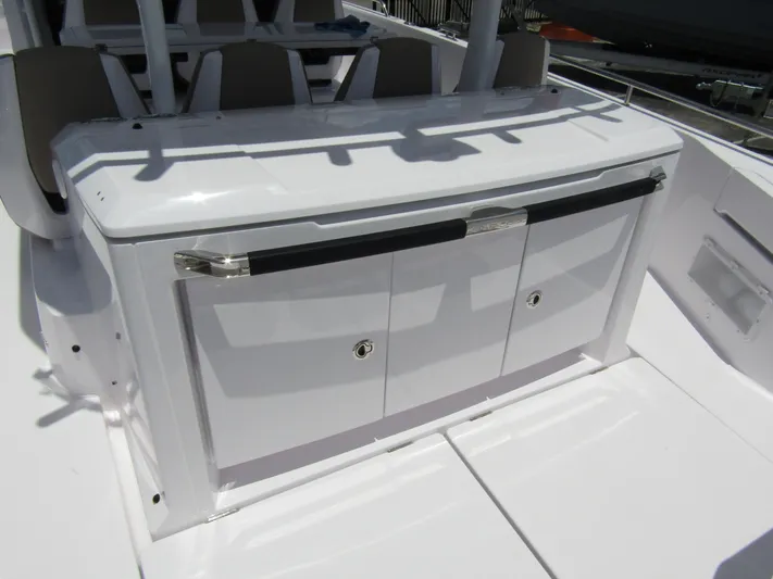  Yacht Photos Pics 2024 Axopar 37 Sun Top boat storage compartment with sleek white finish and secure handles.