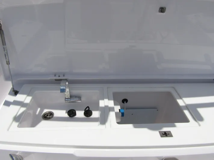  Yacht Photos Pics 2024 Axopar 37 Sun Top boat sink and storage area, featuring modern fixtures.