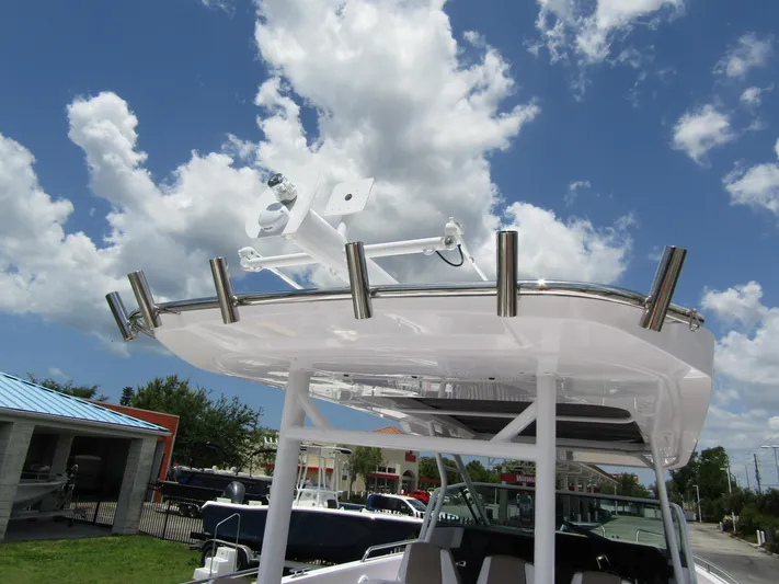  Yacht Photos Pics 2024 Axopar 37 Sun Top boat with stainless steel rod holders under a clear blue sky.