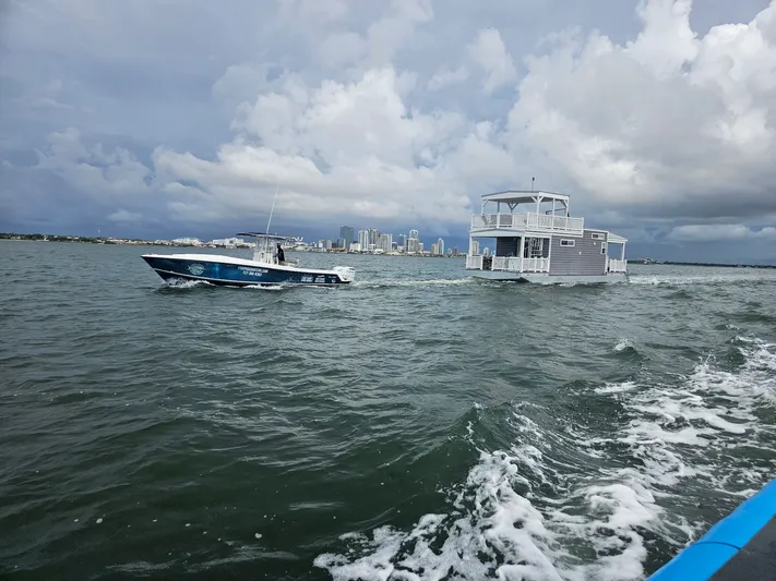  Yacht Photos Pics Houseboat and motorboat on water with city skyline.