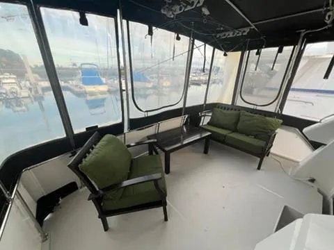 1991 Carver 33 Aft Cabin Motor Yacht interior with green cushioned seating and marina view.