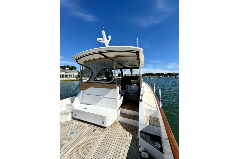 Belle Yacht Photos Pics 2007 Legacy Yachts 34 Sport Express on water, showcasing deck and cabin under clear blue sky.