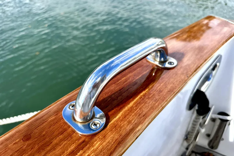 Belle Yacht Photos Pics Polished metal handle on 2007 Legacy Yachts 34 Sport Express, against a wooden surface.