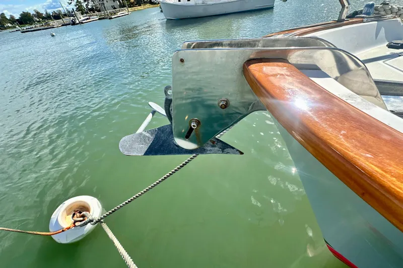 Belle Yacht Photos Pics Bow of 2007 Legacy Yachts 34 Sport Express with anchor, docked in calm waters.