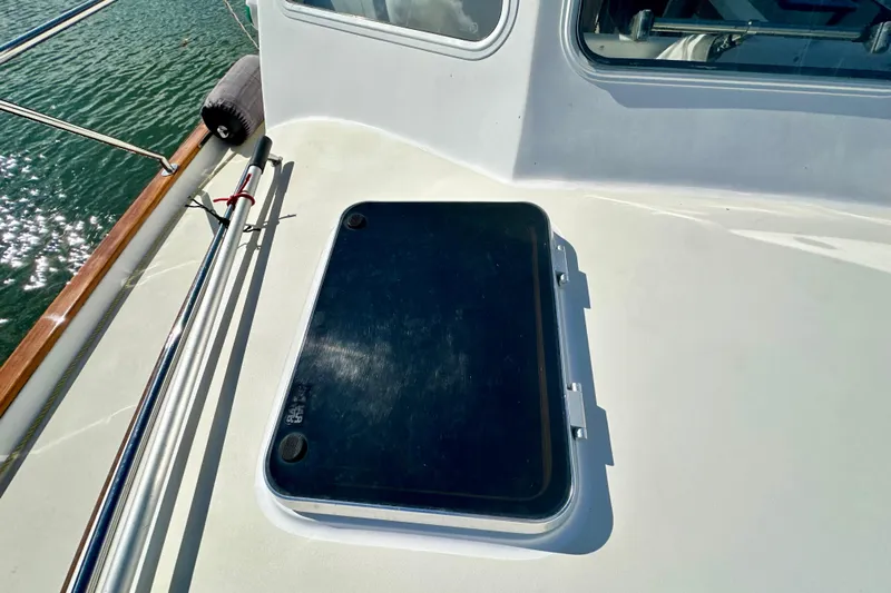 Belle Yacht Photos Pics 2007 Legacy Yachts 34 Sport Express deck with hatch and railing, on calm water.