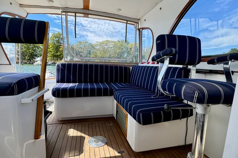 Belle Yacht Photos Pics 2007 Legacy Yachts 34 Sport Express interior with striped seating and wooden flooring.