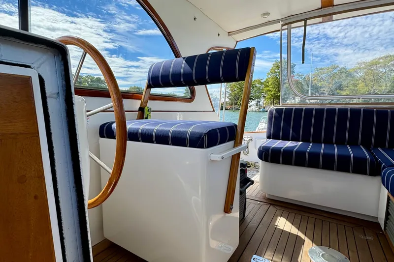 Belle Yacht Photos Pics 2007 Legacy Yachts 34 Sport Express interior with striped seating and wooden accents.