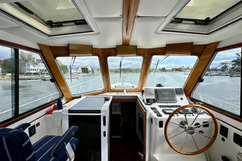 Belle Yacht Photos Pics Interior view of 2007 Legacy Yachts 34 Sport Express helm with scenic waterfront backdrop.