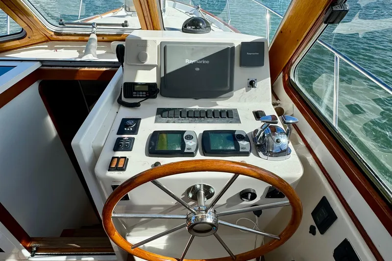 Belle Yacht Photos Pics 2007 Legacy Yachts 34 Sport Express helm with navigation equipment and wooden steering wheel.