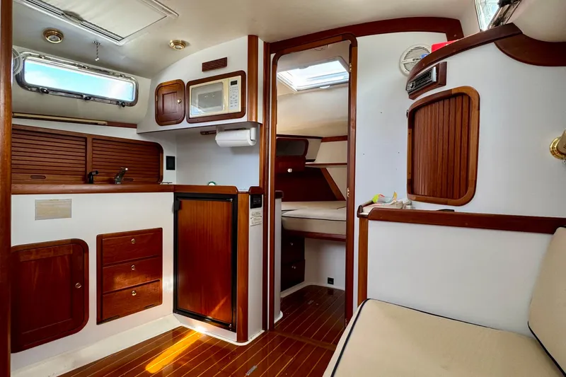 Belle Yacht Photos Pics 2007 Legacy Yachts 34 Sport Express interior with wood accents and compact kitchen area.