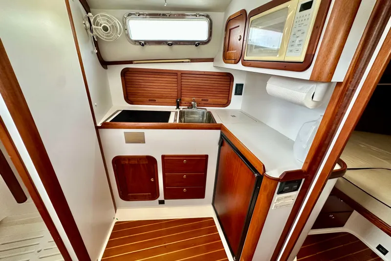 Belle Yacht Photos Pics 2007 Legacy Yachts 34 Sport Express galley with wood accents, sink, and microwave.