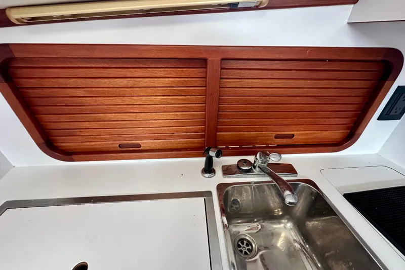 Belle Yacht Photos Pics 2007 Legacy Yachts 34 Sport Express galley with wooden cabinets and stainless steel sink.