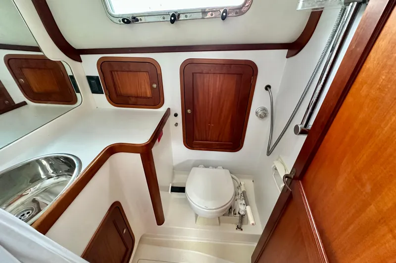 Belle Yacht Photos Pics 2007 Legacy Yachts 34 Sport Express bathroom with wooden cabinets and stainless steel sink.