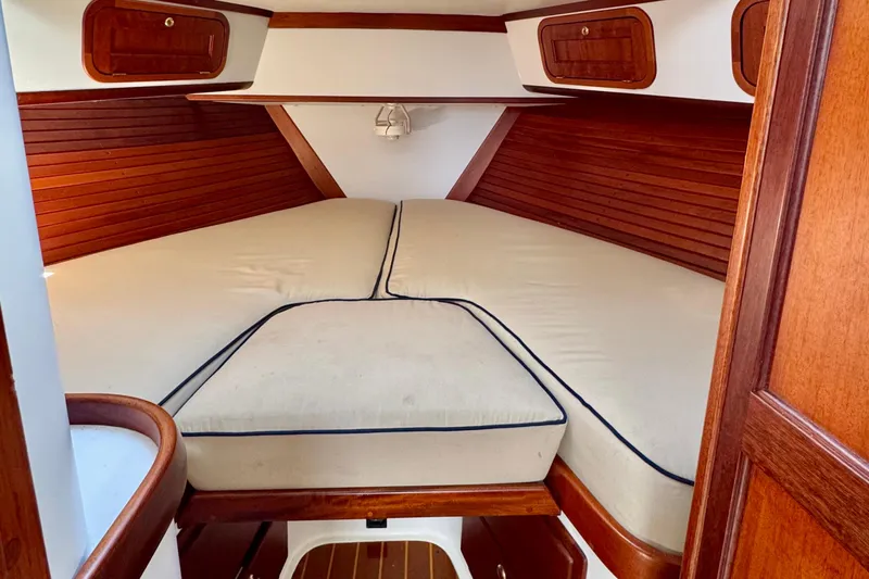 Belle Yacht Photos Pics 2007 Legacy Yachts 34 Sport Express cabin with wooden interior and cushioned bed.