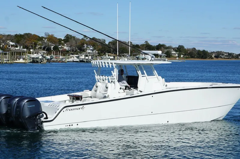  Yacht Photos Pics 2024 Freeman 38 boat cruising on a calm blue lake with scenic shoreline.