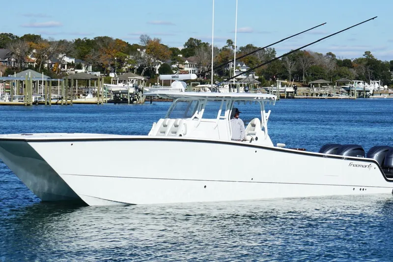  Yacht Photos Pics 2024 Freeman 38 boat cruising on a serene blue lake with scenic background.