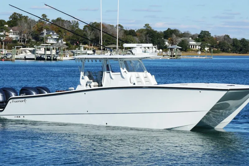  Yacht Photos Pics 2024 Freeman 38 boat cruising on a serene lake with a scenic background.