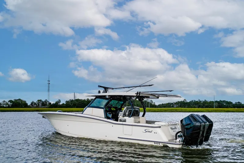 Your Next Boat! Yacht Photos Pics 2024 Scout 377 LXF boat cruising on a calm river under a blue sky.