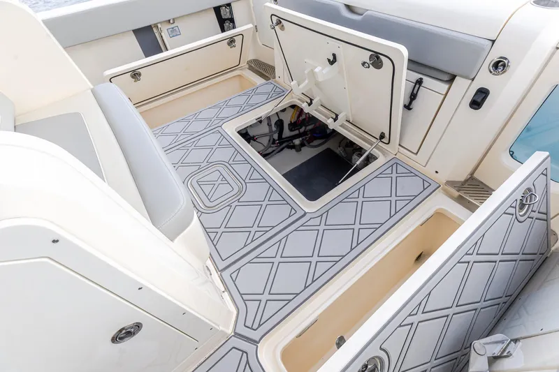 Your Next Boat! Yacht Photos Pics 2024 Scout 377 LXF boat interior with open storage compartments and patterned flooring.