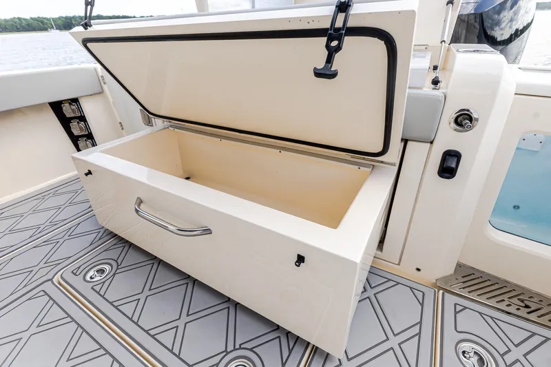 Your Next Boat! Yacht Photos Pics 2024 Scout 377 LXF boat storage compartment with open lid on deck.