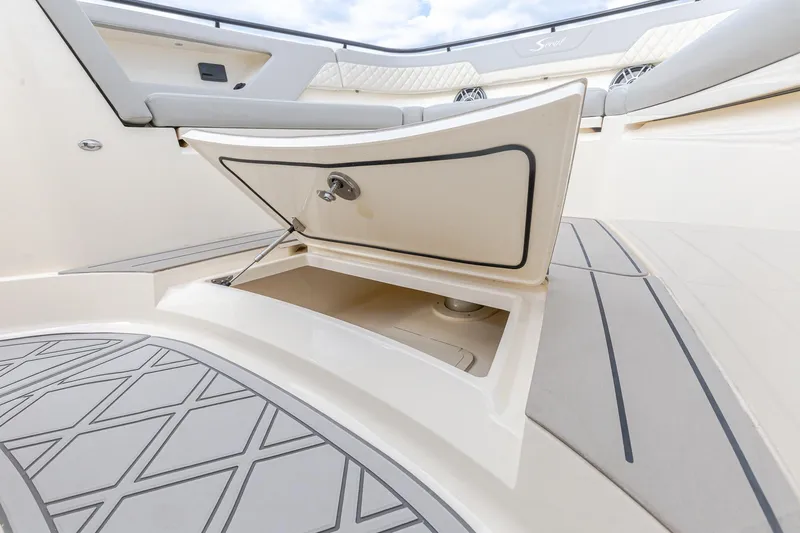 Your Next Boat! Yacht Photos Pics 2024 Scout 377 LXF boat storage compartment with open hatch and cushioned seating.