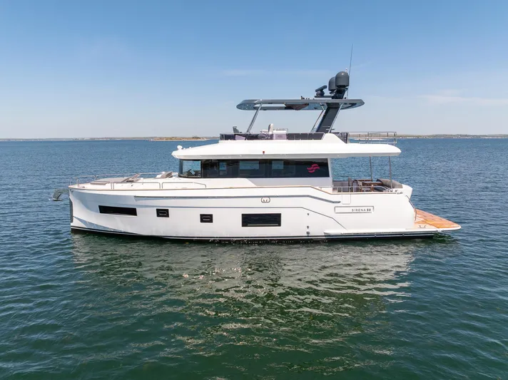 New 2024 Sirena 58 Yacht Photos Pics 2024 Sirena 58 Flybridge yacht on calm blue water, side view.