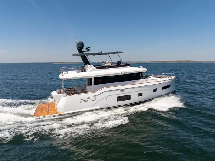 New 2024 Sirena 58 Yacht Photos Pics 2024 Sirena 58 Flybridge yacht cruising on open water under clear skies.