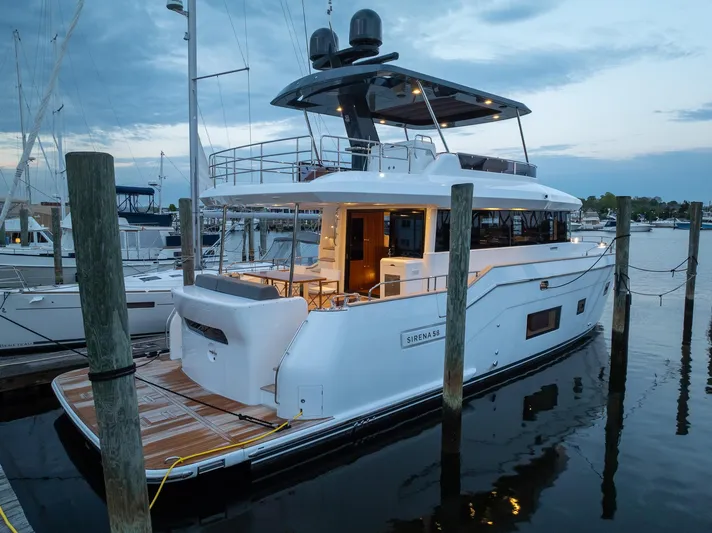 New 2024 Sirena 58 Yacht Photos Pics 2024 Sirena 58 Flybridge yacht docked at marina during twilight.