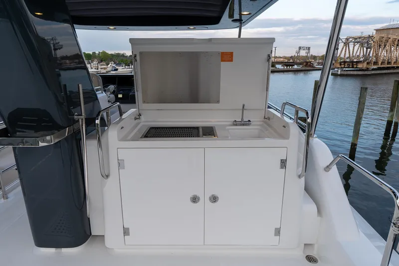 New 2024 Sirena 58 Yacht Photos Pics 2024 Sirena 58 Flybridge yacht outdoor kitchen with sink and grill by the water.