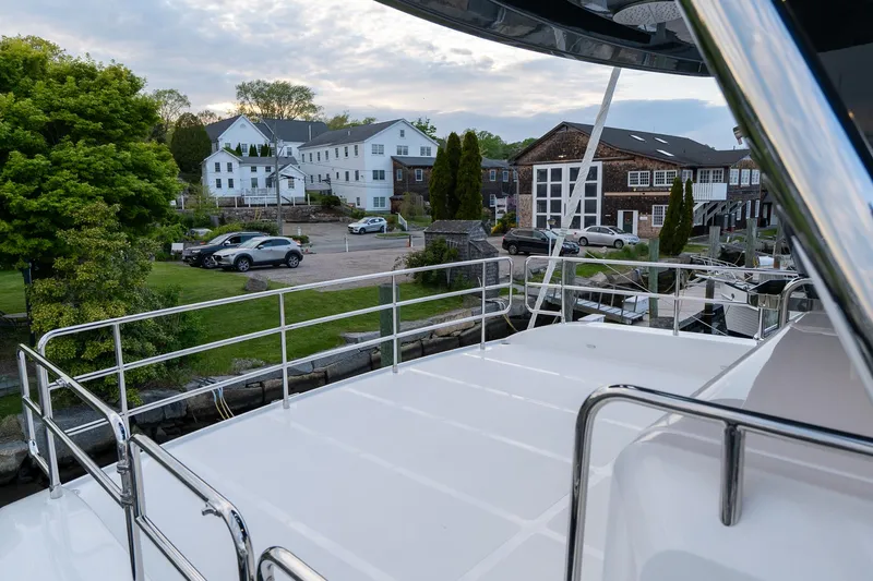 New 2024 Sirena 58 Yacht Photos Pics 2024 Sirena 58 Flybridge yacht docked near charming waterfront buildings.