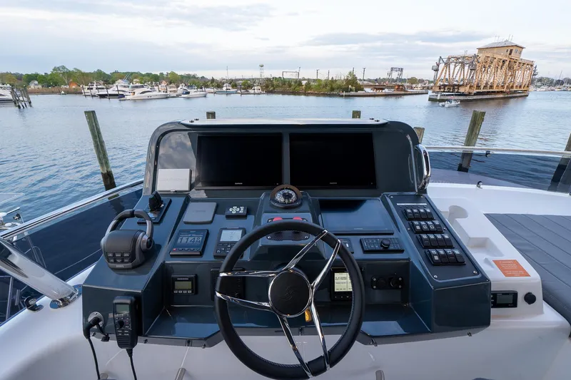 New 2024 Sirena 58 Yacht Photos Pics 2024 Sirena 58 Flybridge helm with dual screens, steering wheel, and waterfront view.