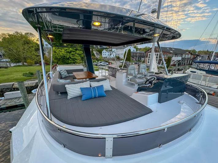 New 2024 Sirena 58 Yacht Photos Pics 2024 Sirena 58 Flybridge yacht with spacious deck, seating, and scenic marina view.
