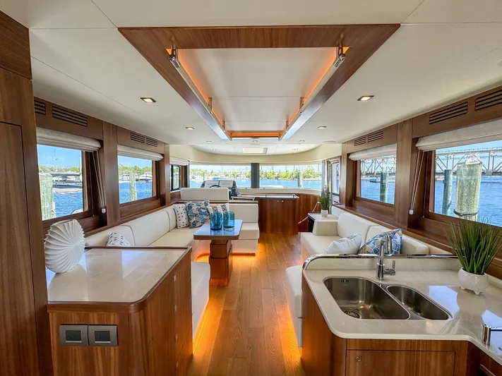 New 2024 Sirena 58 Yacht Photos Pics Luxurious interior of 2024 Sirena 58 Flybridge yacht with elegant wood finishes and panoramic windows.