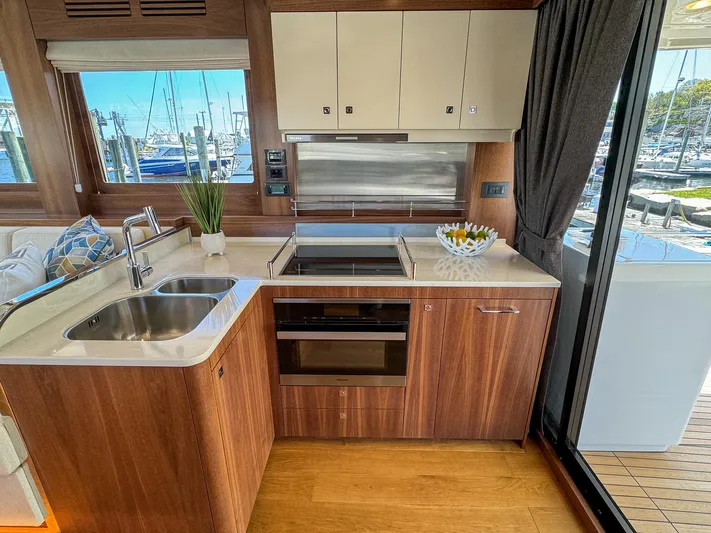 New 2024 Sirena 58 Yacht Photos Pics Luxurious 2024 Sirena 58 Flybridge yacht kitchen with modern appliances and elegant wood finish.