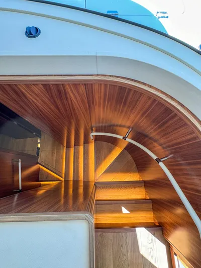 New 2024 Sirena 58 Yacht Photos Pics Curved wooden staircase on 2024 Sirena 58 Flybridge yacht, showcasing elegant design.