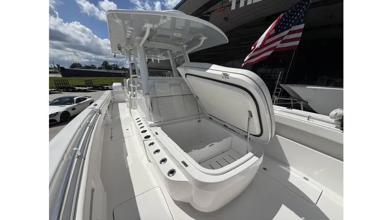  Yacht Photos Pics 2022 Invincible 33 Catamaran with open storage compartment, American flag, and clear sky background.