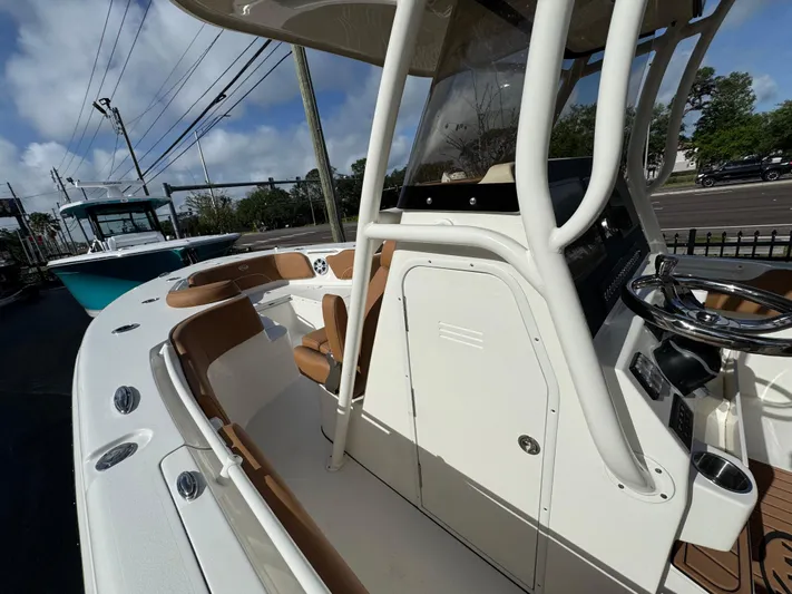  Yacht Photos Pics 2025 Key West 291 FS boat interior with helm, seating, and console under a clear sky.