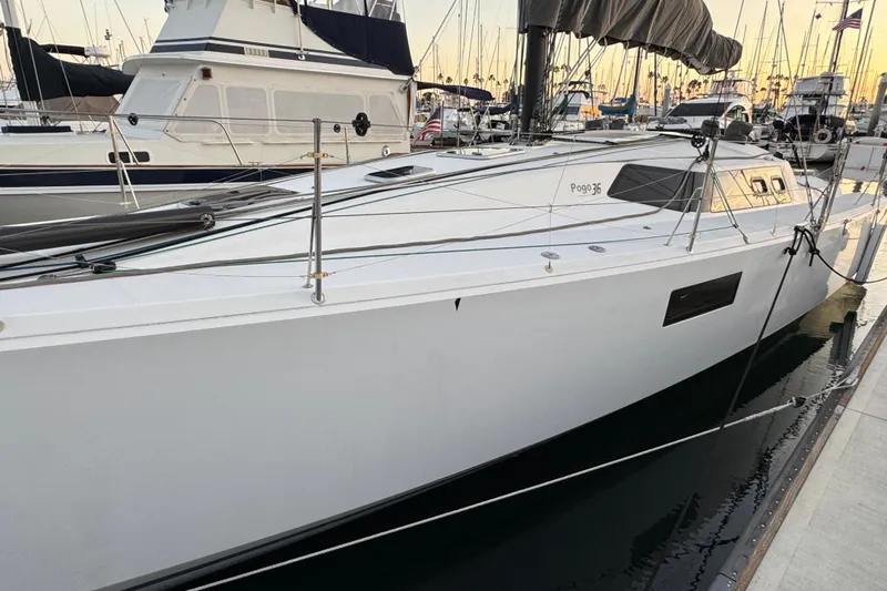 Expresso Yacht Photos Pics 2019 Pogo 36 sailboat docked at marina, sleek white design, calm water reflection.