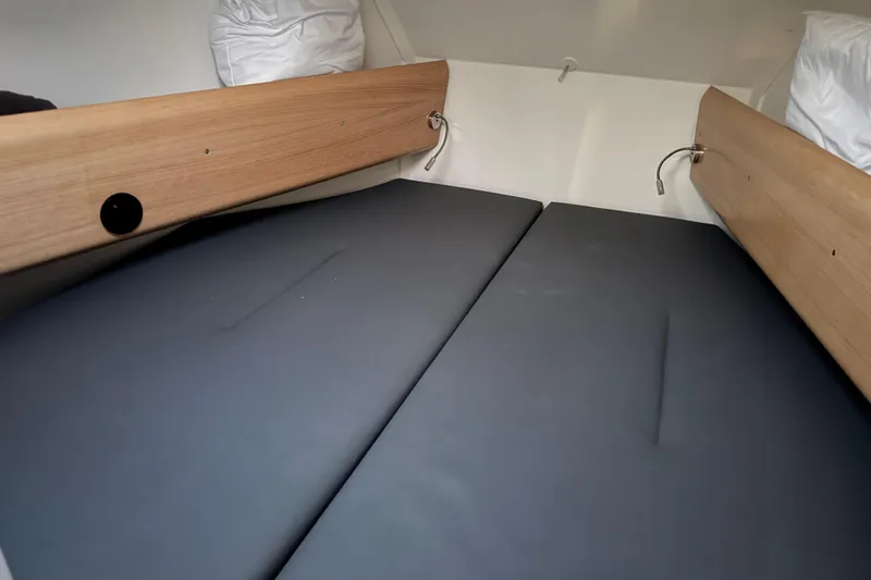 Expresso Yacht Photos Pics Cozy cabin interior of 2019 Pogo 36 sailboat with wooden accents and cushioned bedding.