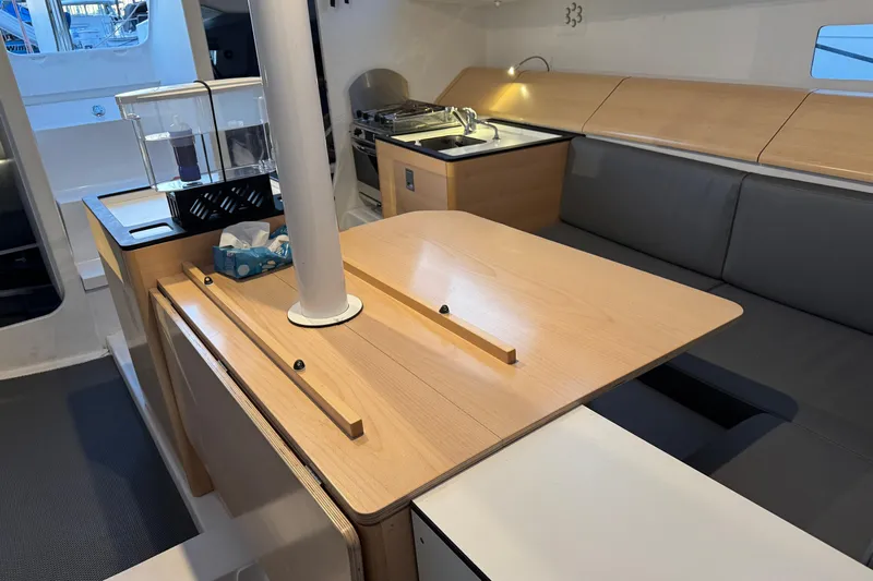 Expresso Yacht Photos Pics Modern interior of 2019 Pogo 36 sailboat with wooden table and kitchenette.