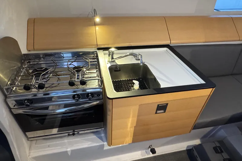 Expresso Yacht Photos Pics Compact kitchen in 2019 Pogo 36 yacht with stove, sink, and wooden cabinetry.