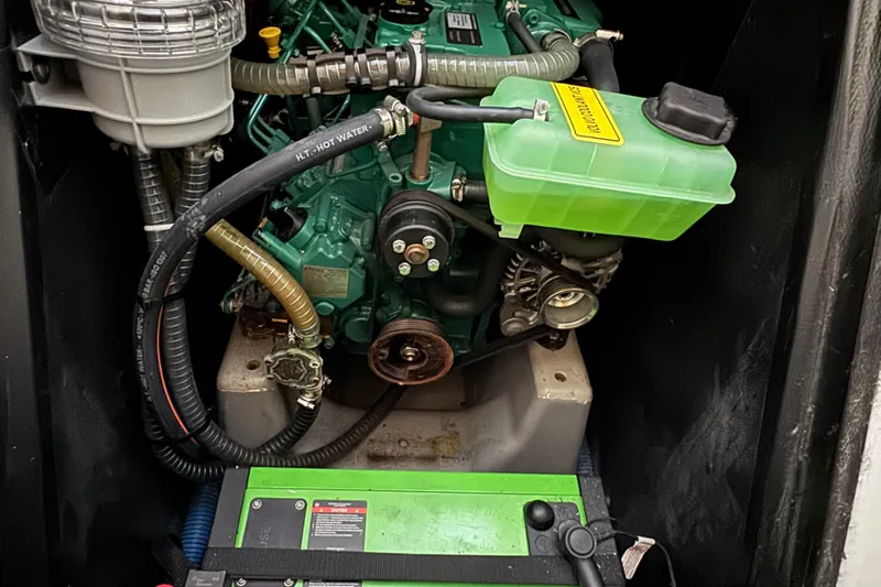 Expresso Yacht Photos Pics Engine compartment of a 2019 Pogo 36 sailboat, featuring hoses and a green battery.