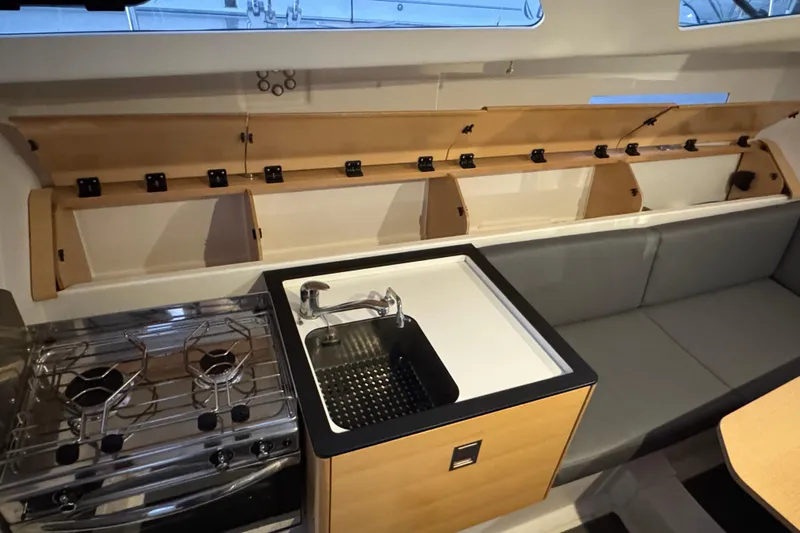 Expresso Yacht Photos Pics Compact kitchen area in 2019 Pogo 36 sailboat with stove, sink, and seating.
