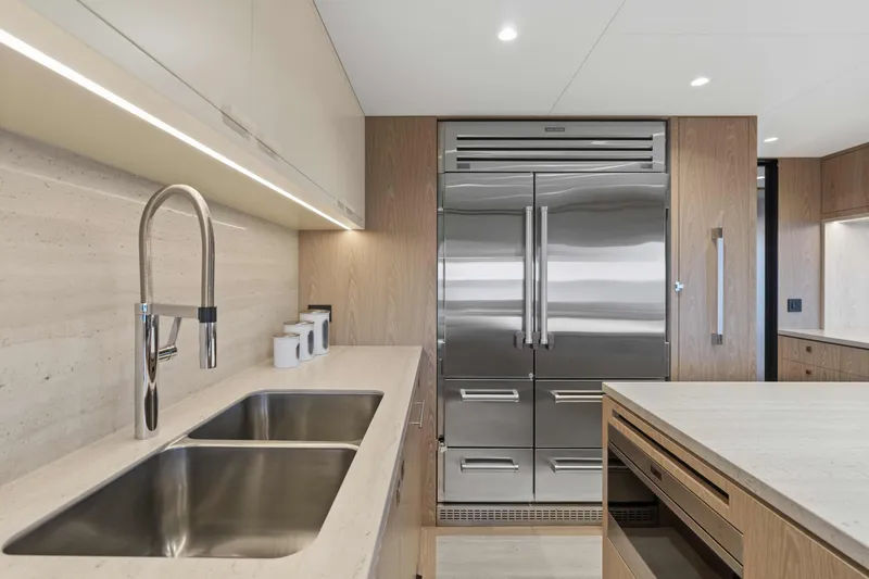 Horizon Fd100-914 / Available Flibs 2025 Yacht Photos Pics Modern kitchen with stainless steel appliances, dual sink, and sleek cabinetry in Horizon FD100 yacht.